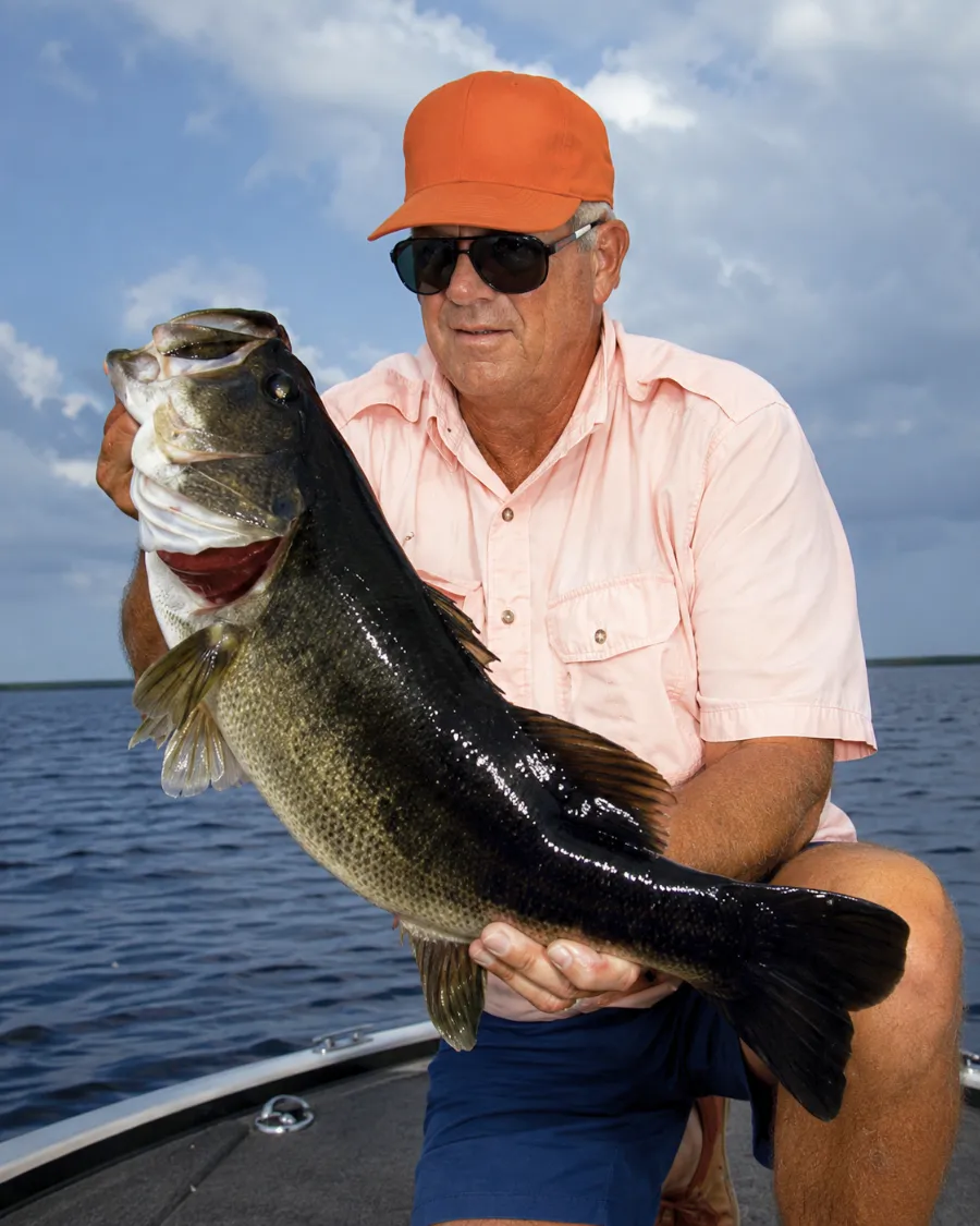 Angler holding a giant Florida-strain largemouth bass on Lake Okeechobee in Florida.